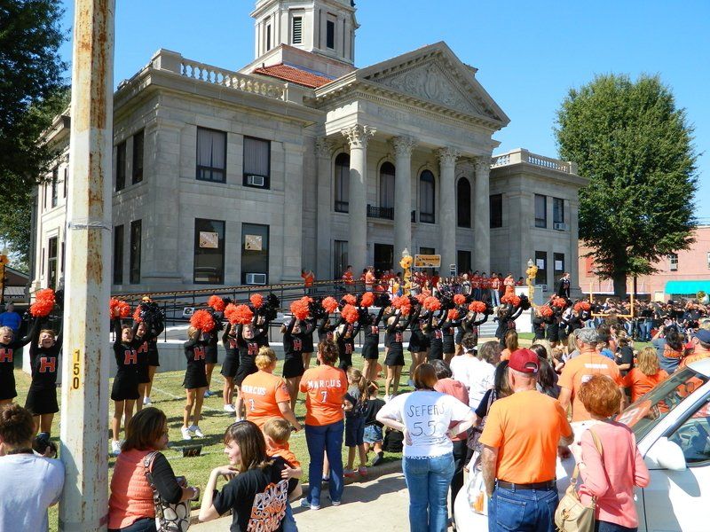 A group of cheerleaders are standing in front of a large building