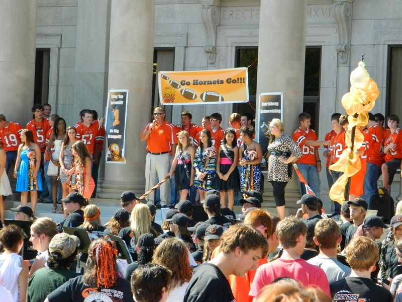 A crowd of people are gathered in front of a sign that says 