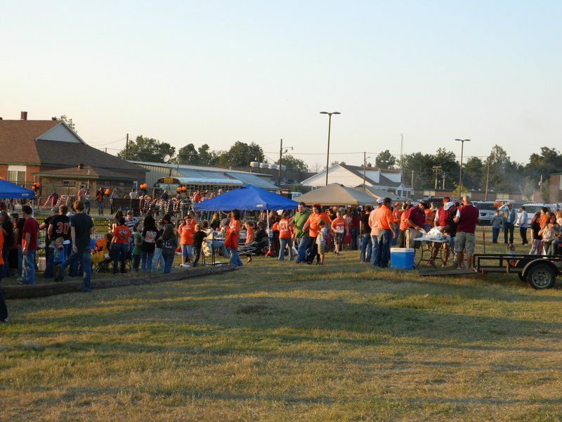 A large group of people are gathered in a grassy field