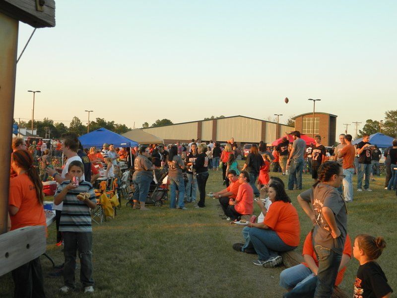 A group of people are gathered in a field and one of them is wearing a shirt with the number 25 on it