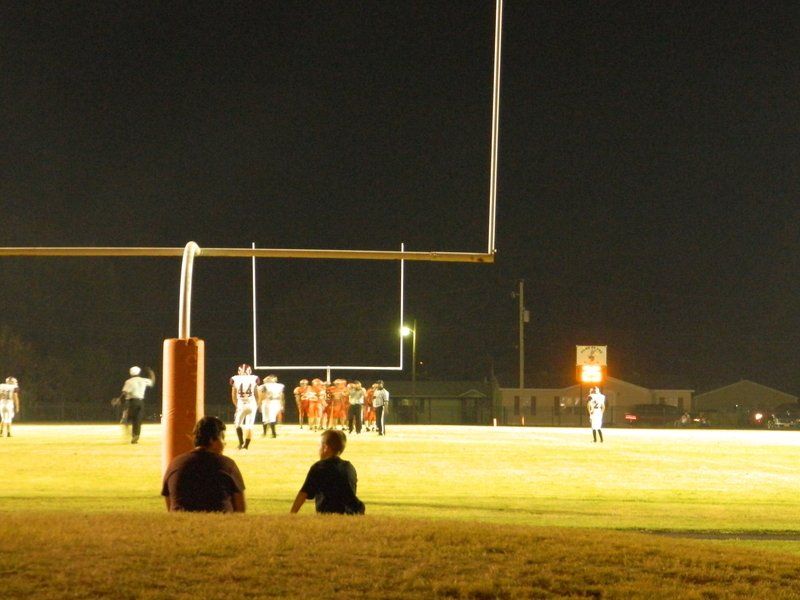 A group of people watching a football game at night