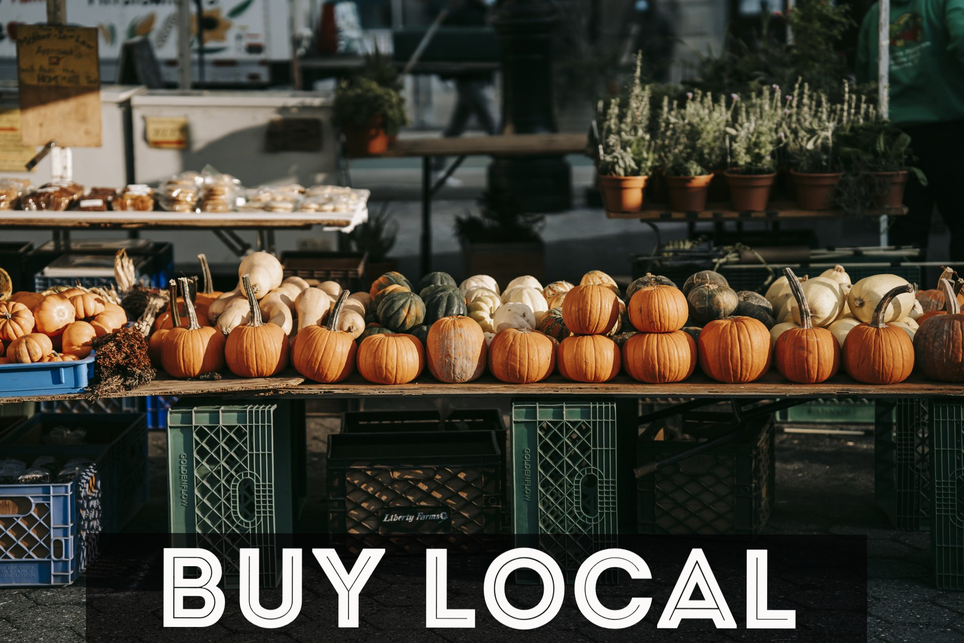 A bunch of pumpkins are sitting on a table at a farmers market.