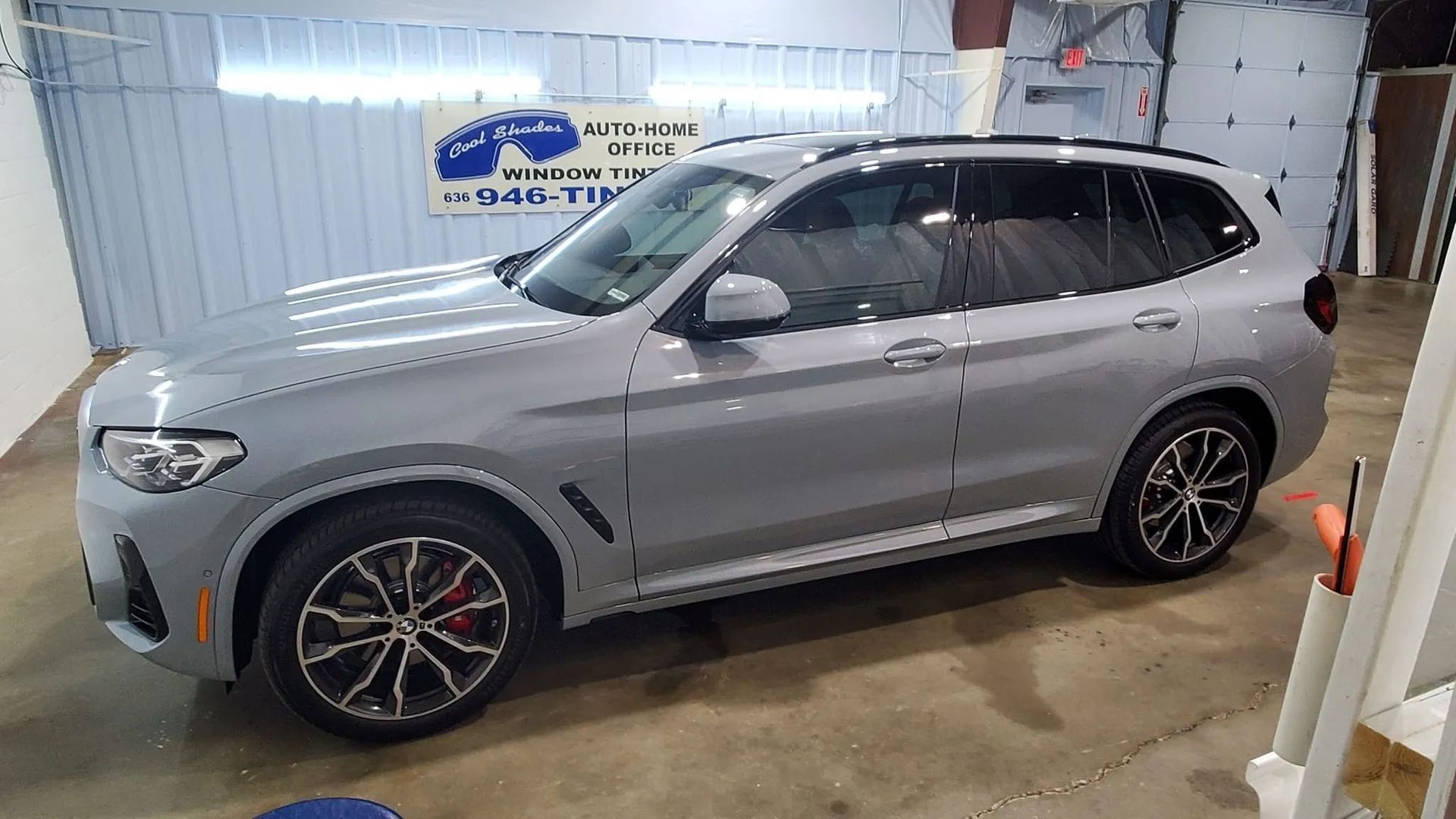 Silver SUV parked inside a garage, side view.