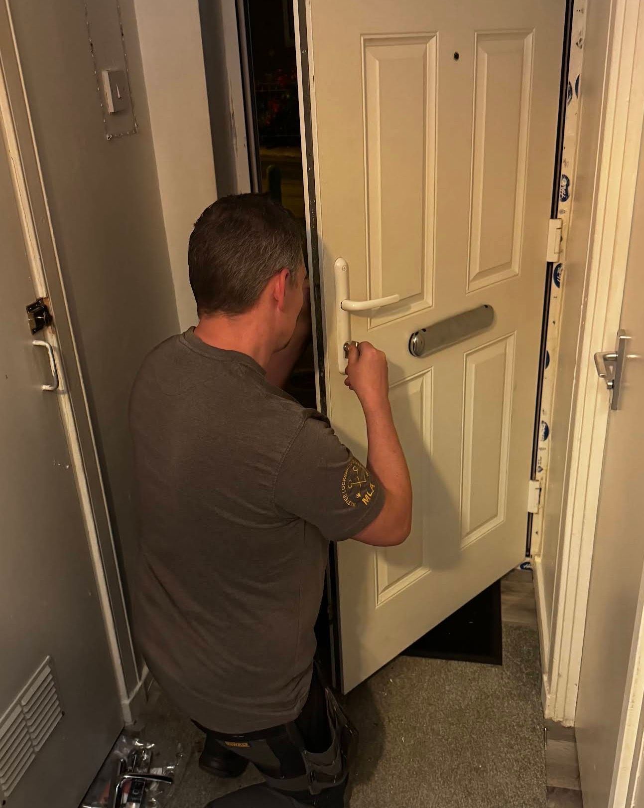 Gerry from The Key Locksmith carrying out a non-destructive emergency lock opening on a white composite front door. The door is partially open while access is gained using specialist locksmith tools, demonstrating professional lockout assistance and composite door expertise.