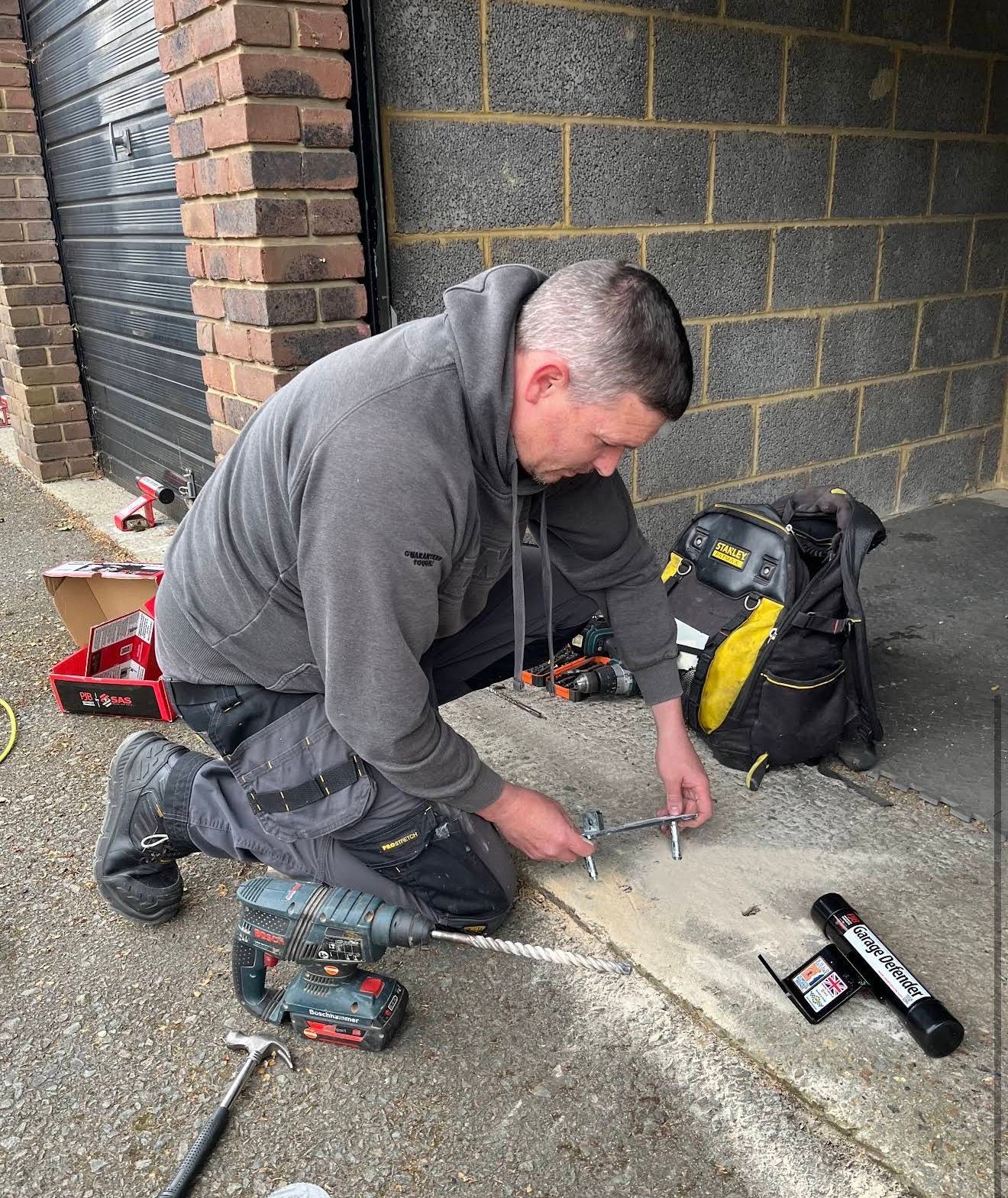 Gerry from The Key Locksmith installing a garage defender on a garage door in Orpington to improve security and help protect tools, bikes and belongings from forced entry.
