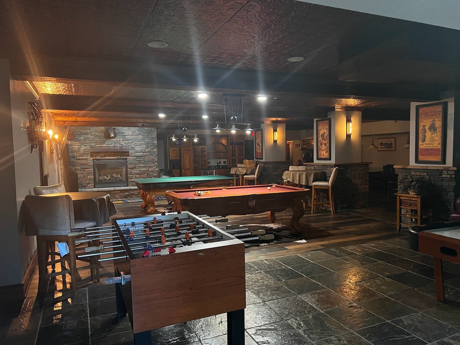A large room with pool tables and foosball tables