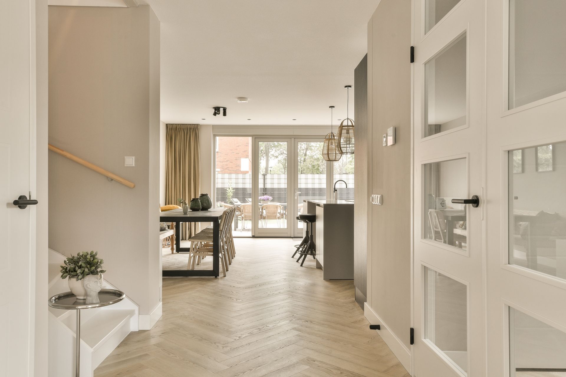 Un sous-sol moderne avec un grand canapé d'angle blanc agrémenté de coussins jaunes, un pouf assorti et un parquet clair.