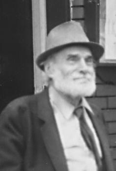 Un homme avec une barbe portant un chapeau et une cravate