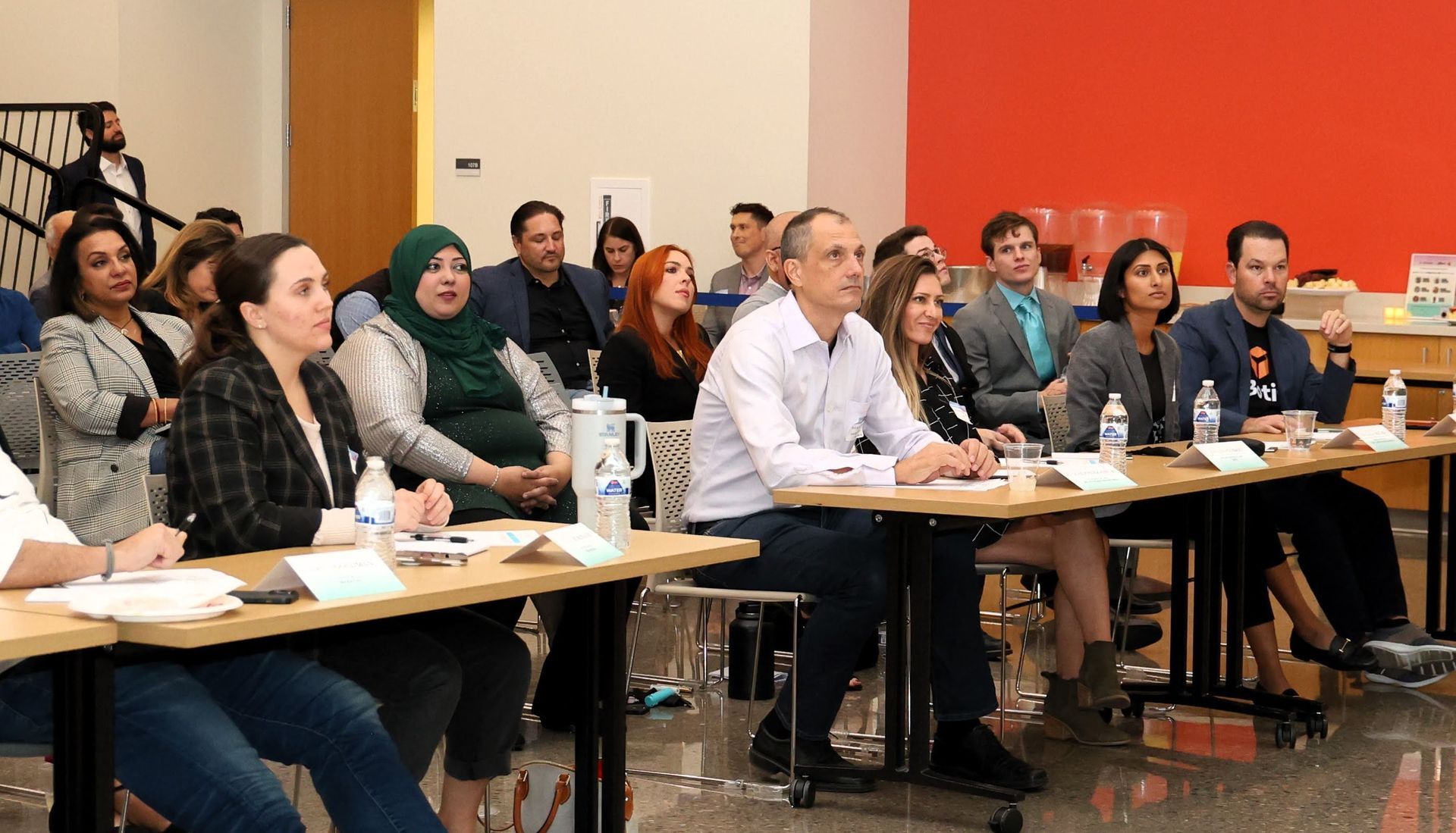 A group of people are sitting at tables in a room.