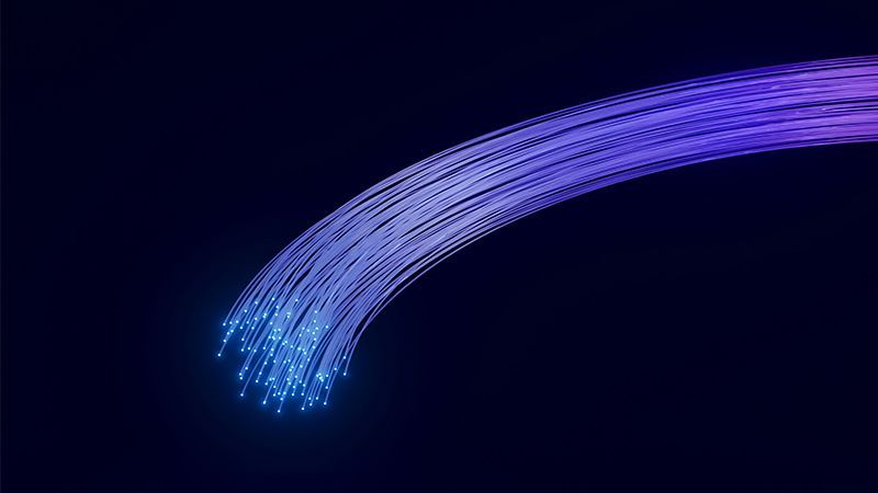 Fibre optic strands glowing blue on black background.