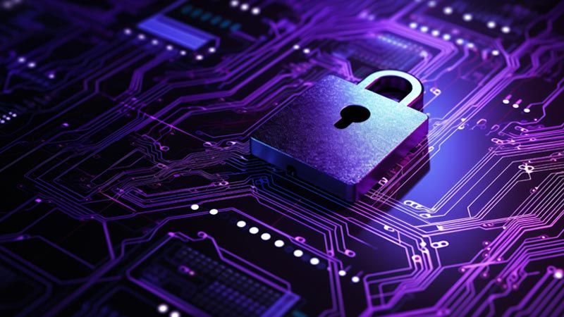 A darkly lit circuitboard with a flat padlock lying on top – purple tint