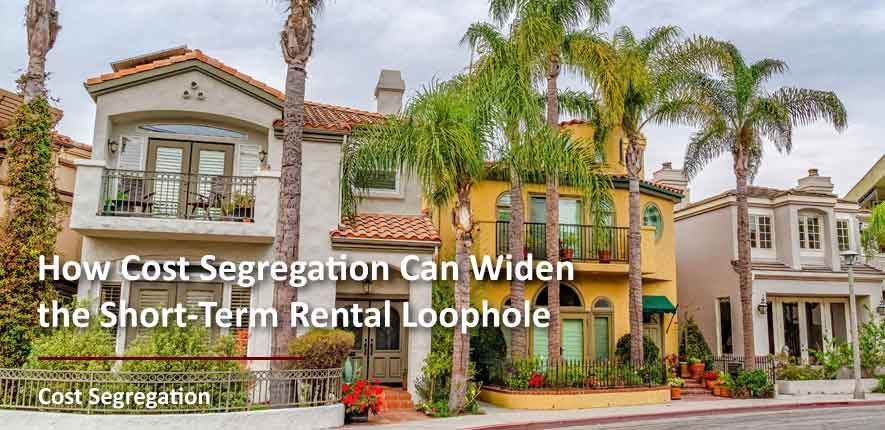 A row of houses with palm trees in front of them.