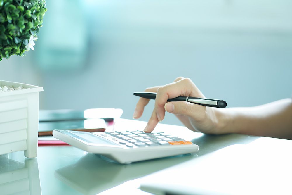 A Person Is Using A Calculator And Holding A Pen — Psychology Practice In Tweed Heads, NSW