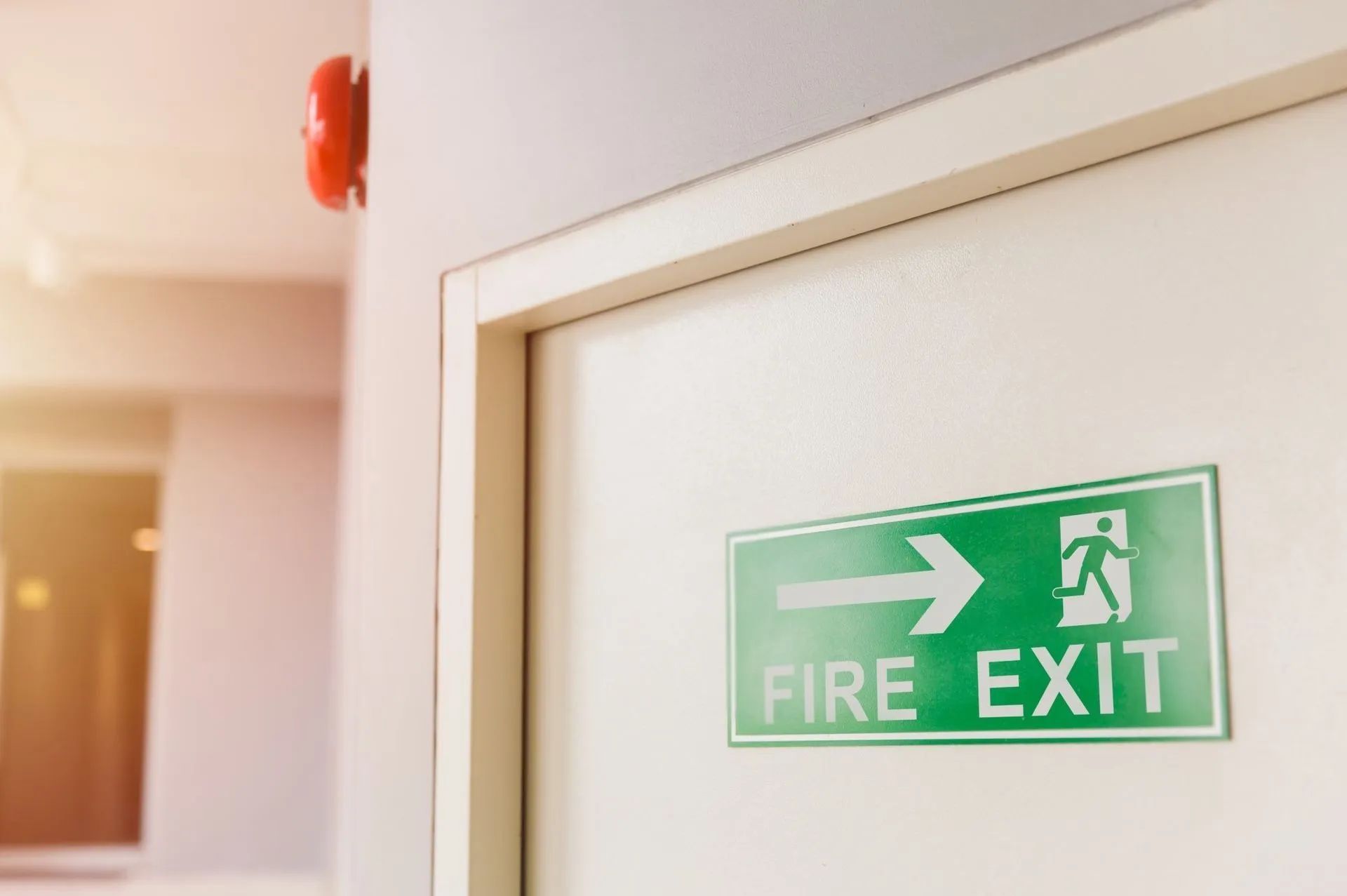 Green fire exit sign with directional arrow on a wall