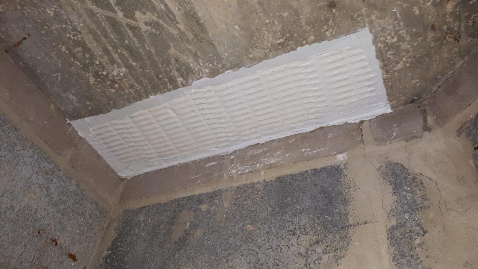 White fire stopping mastic applied to a wall penetration