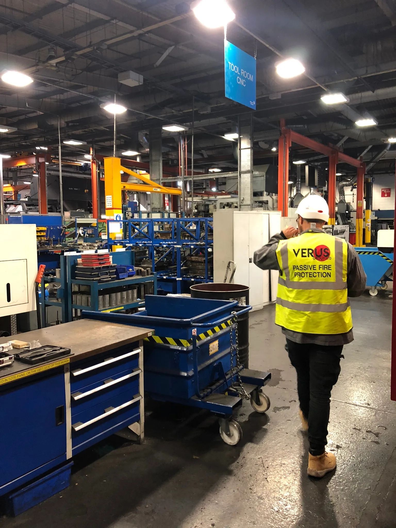 Verus Group passive fire protection technician walking through a factory