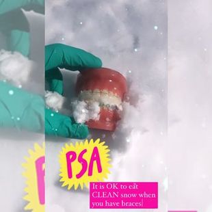 Gloved hand holds a red dental model partly covered in snow; PSA text warns not to eat clean snow.