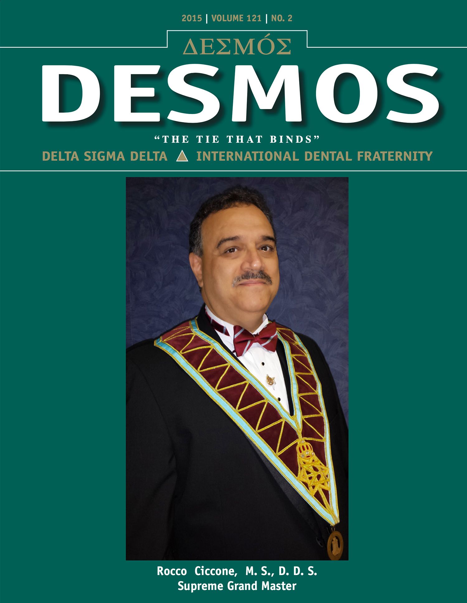 Magazine cover titled “DESMOS” with a formal portrait of a man in a black suit and green ceremonial sash