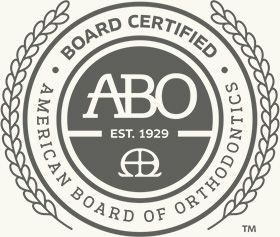 ABO board-certified American Board of Orthodontics seal in gray and white