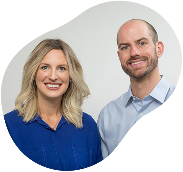 Two smiling professionals, one in a blue blouse and one in a light blue shirt, on a white background