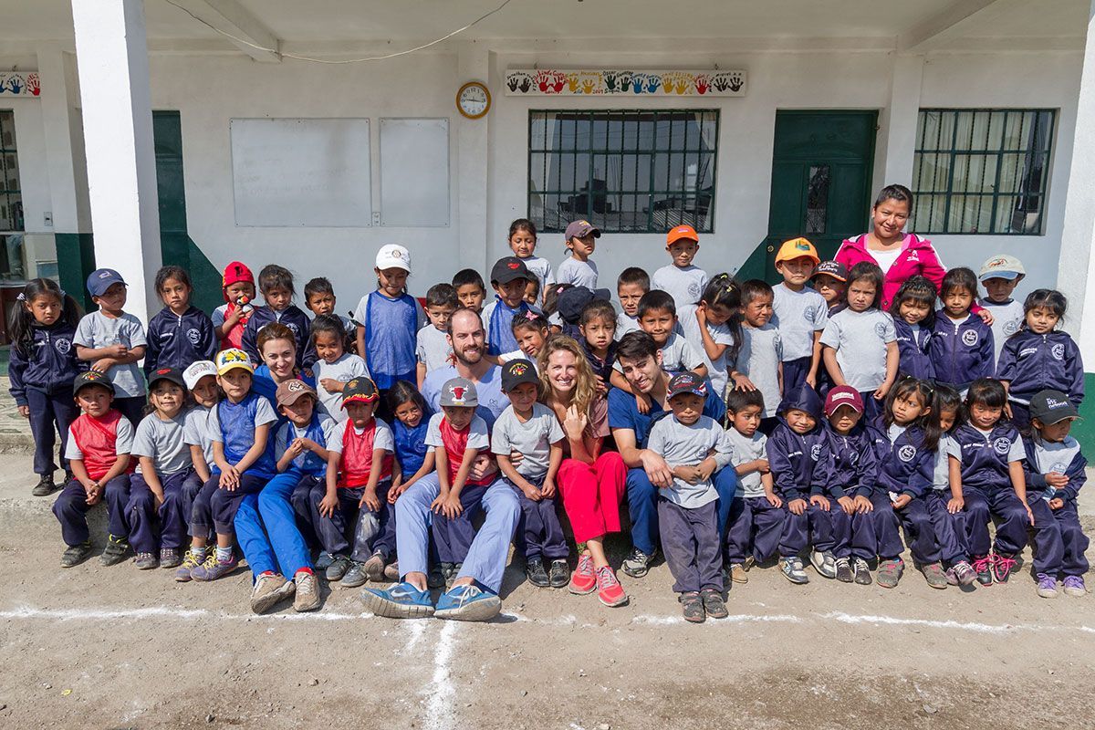 Group of schoolchildren posing for a class photo outside a school building
