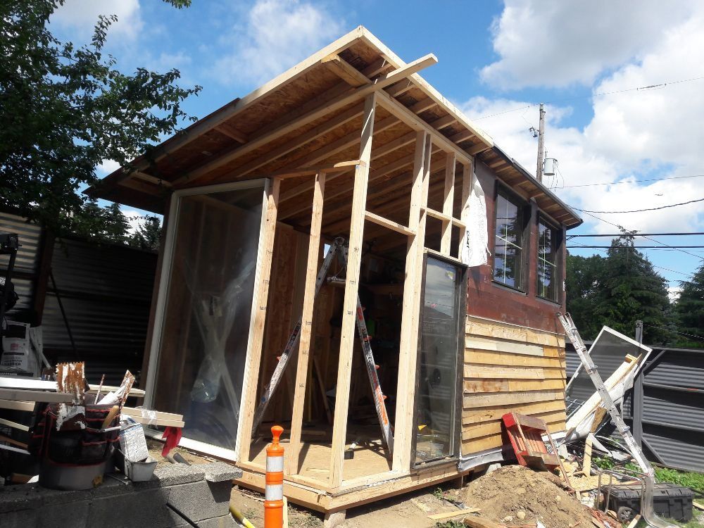 A small wooden house is being built in a backyard