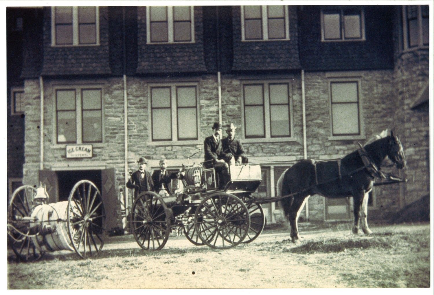Members with a horse-drawn hose wagon and hose reel.