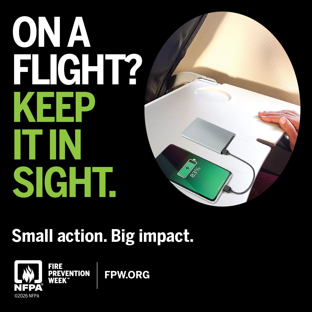 On a flight? Keep it in sight. A phone charging from a power bank on an airplane tray table. Fire Prevention Week 2026, NFPA.