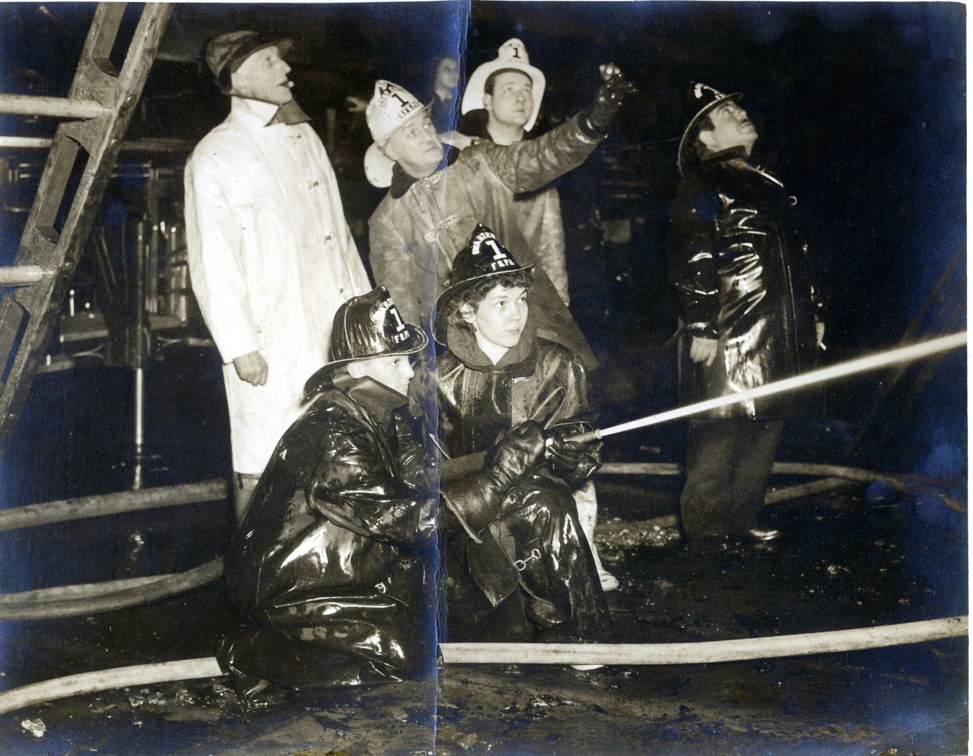 Members work a hose line at a night fire.