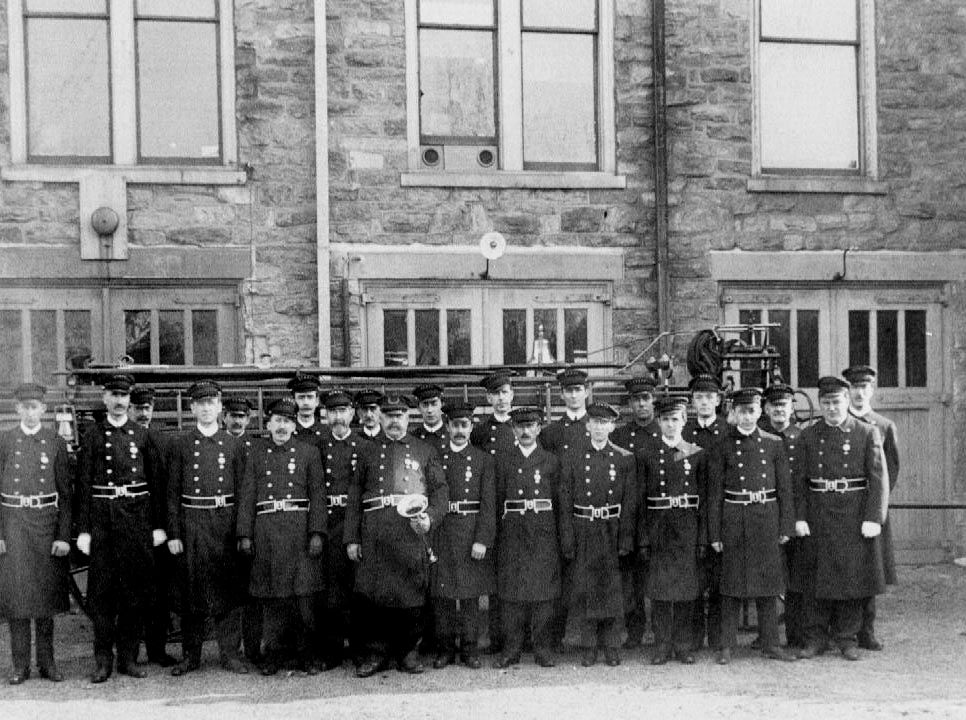 Members in SF&PA parade uniform in front of the firehouse.