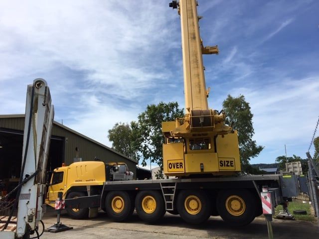 A Semi Truck is Carrying an Excavator Down a Road — Kelly's Crane Hire in Mossman, QLD