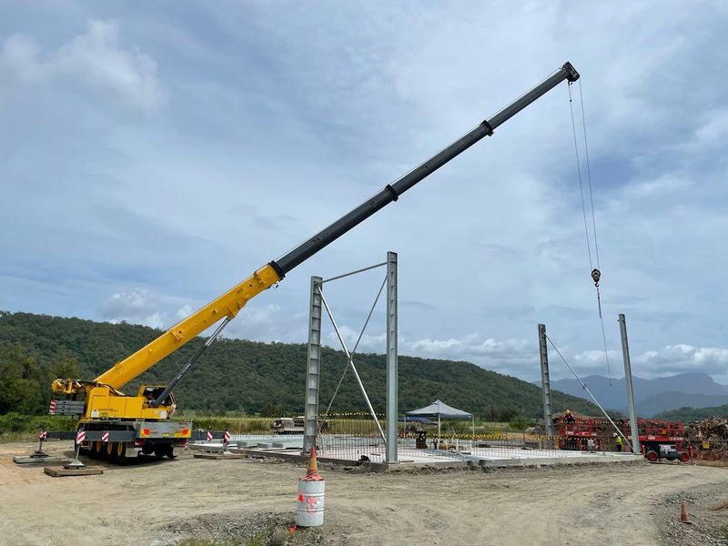 A Large Yellow Crane is Sitting on Top of a Dirt Field — Kelly's Crane Hire in Mossman, QLD