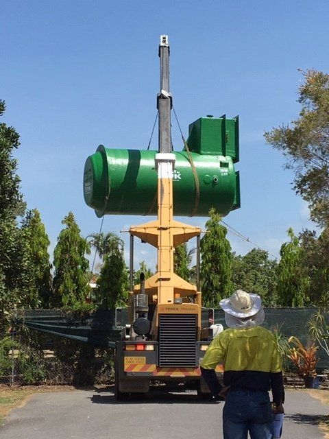 A Large Green Tank is Being Lifted by a Crane — Kelly's Crane Hire in Mossman, QLD