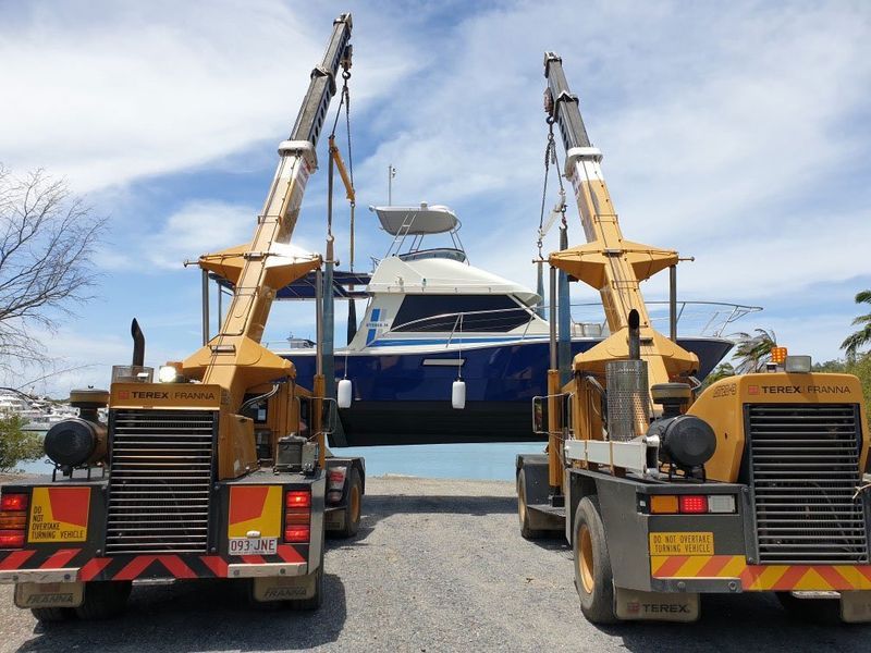 A Boat is Being Lifted by a Crane on a Trailer — Kelly's Crane Hire in Mossman, QLD