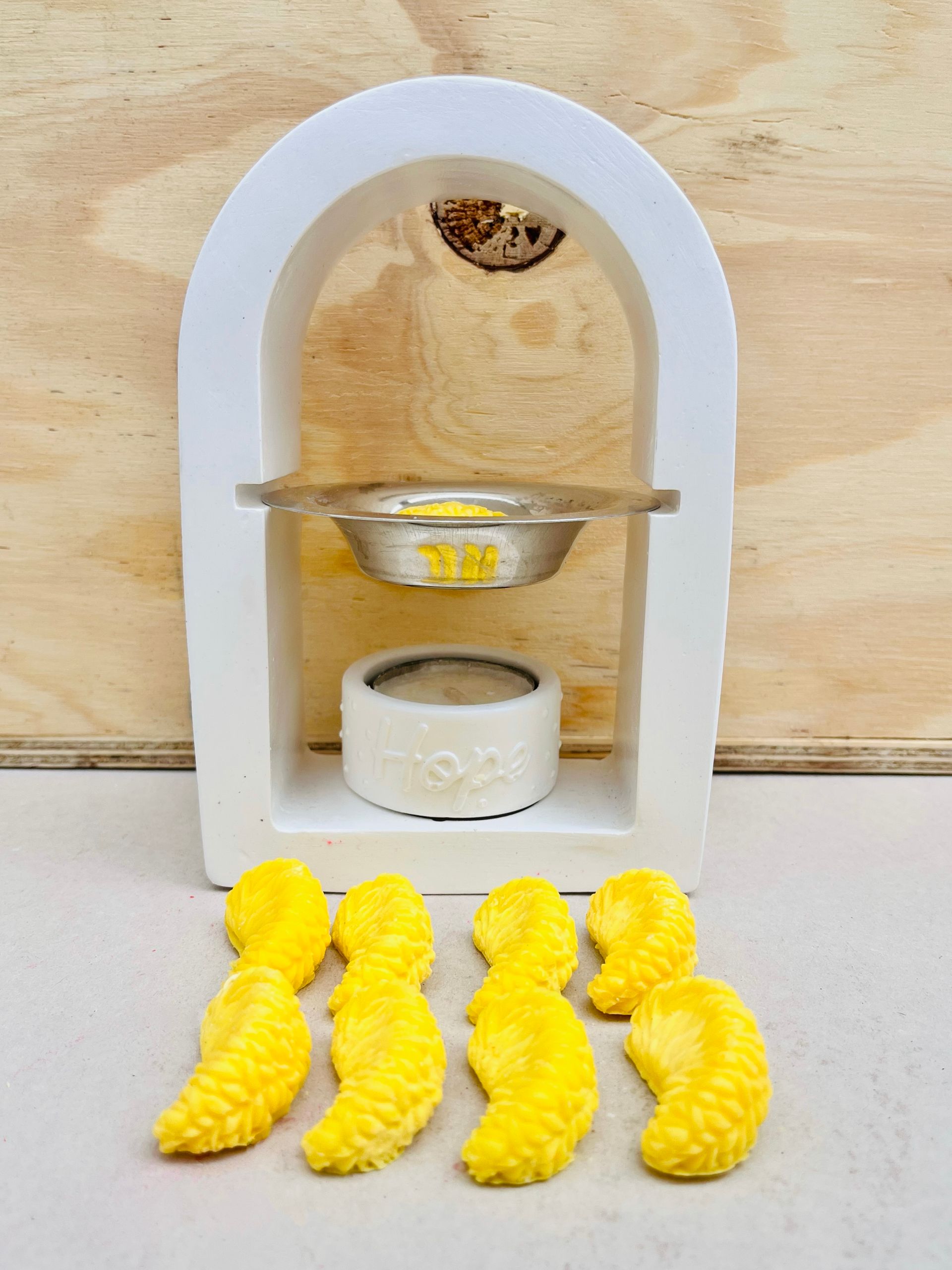 Expositor en miniatura de arco blanco con dos cuencos pequeños y cuatro piezas amarillas.