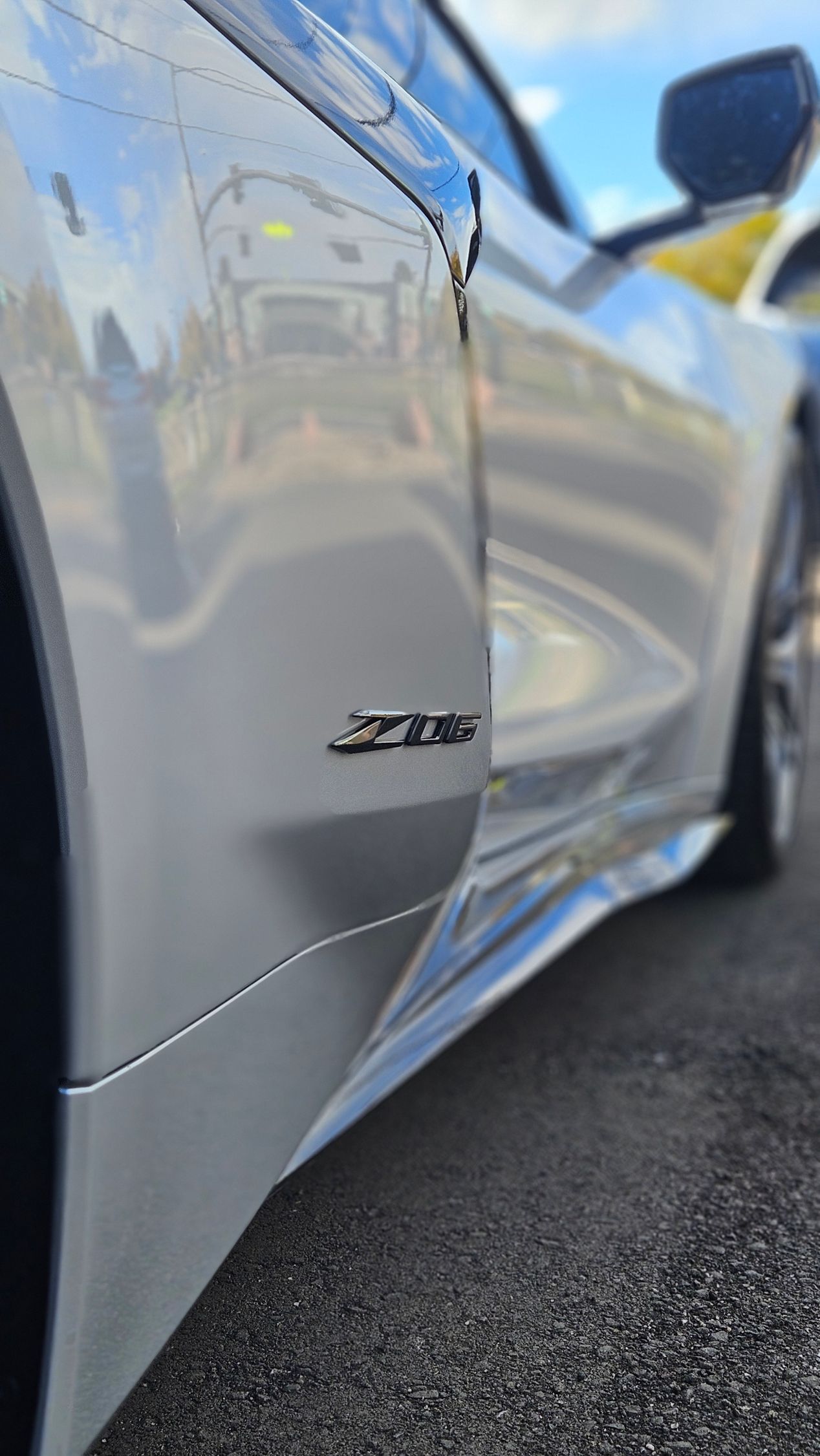 Silver Chevrolet Corvette Z06, side view, parked outdoors, Z06 badge visible.