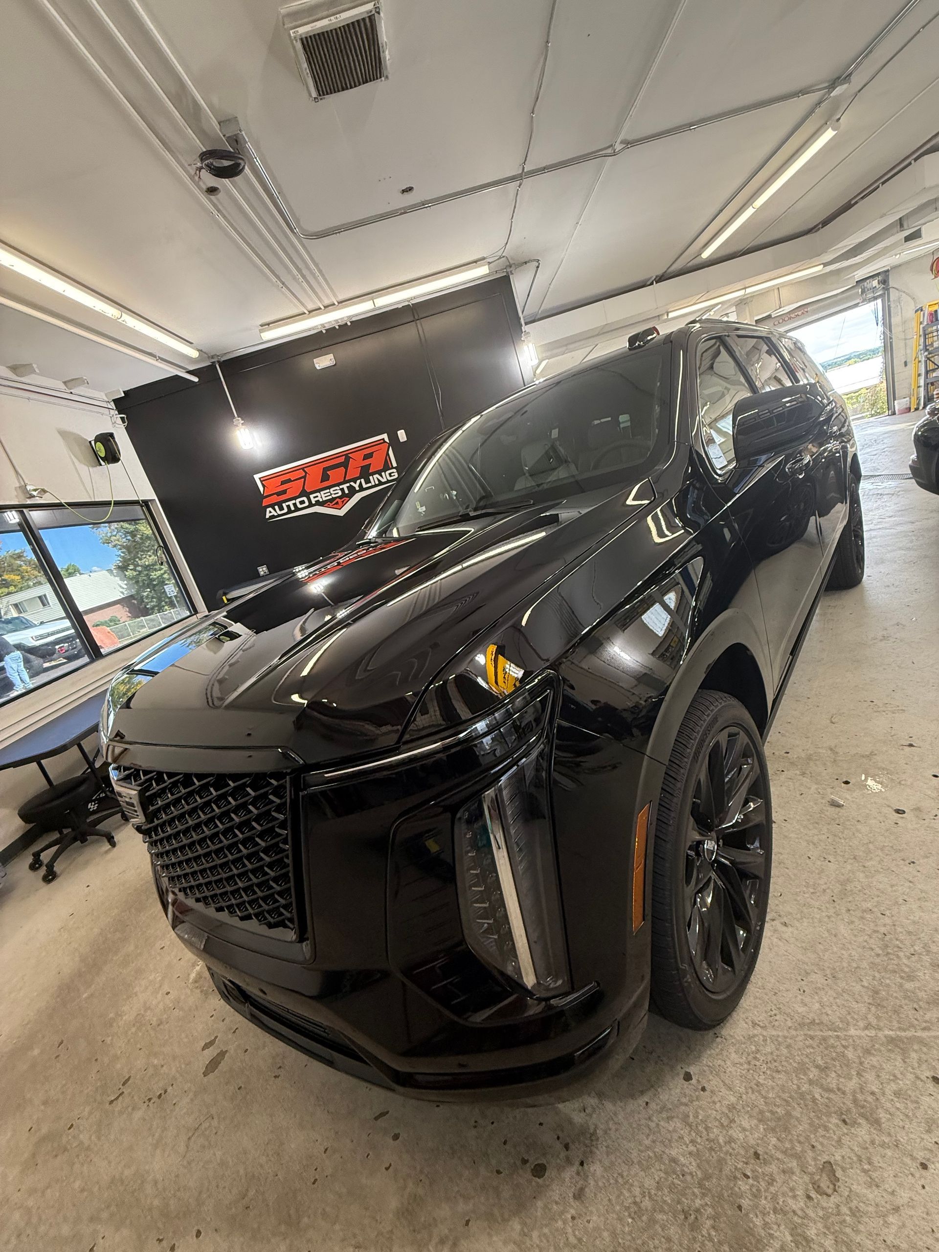 Black SUV in a workshop, facing the camera.