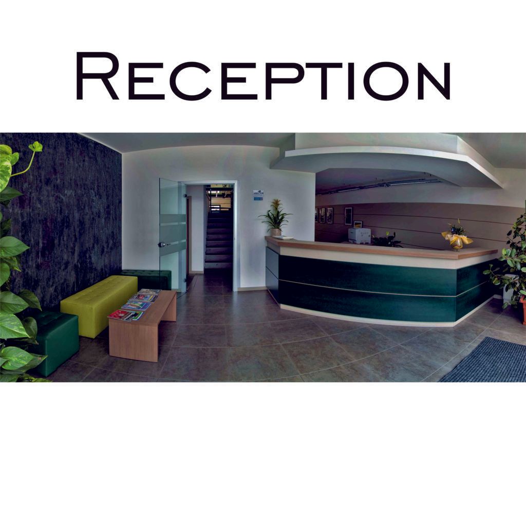 Area reception dell'hotel con bancone e posti a sedere.