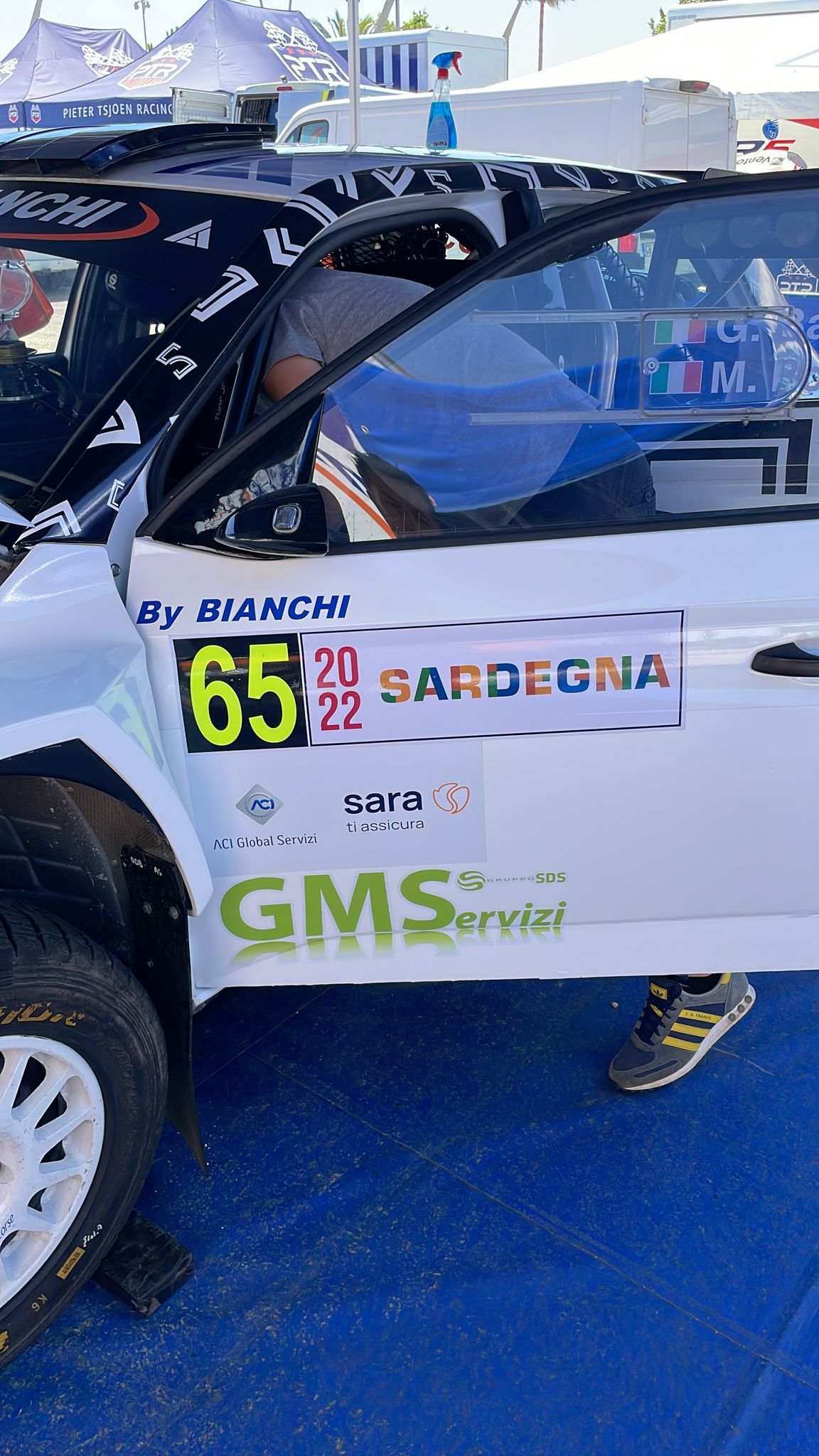 Auto da corsa bianca, portiera aperta, numero 65, adesivo 