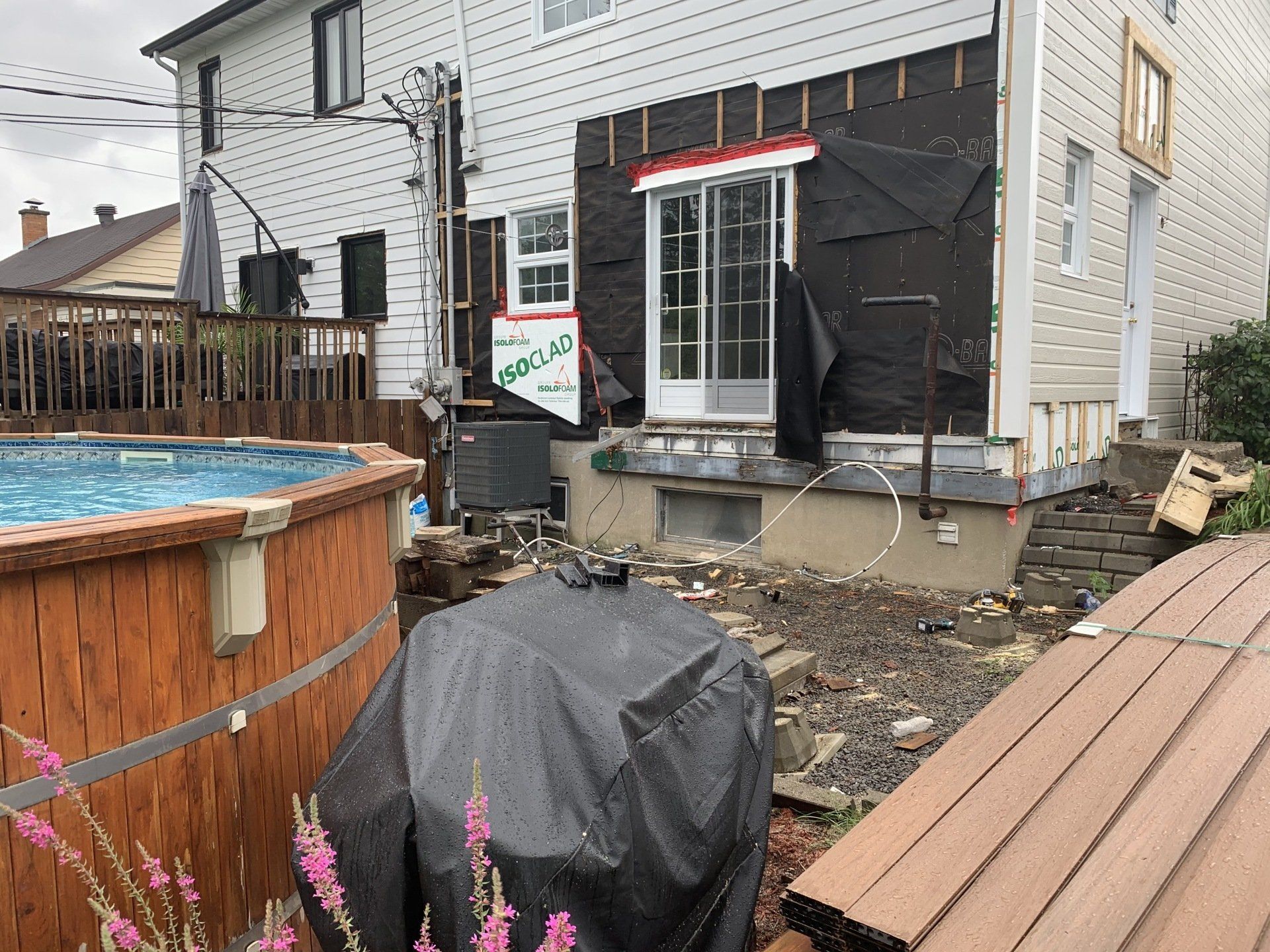 Terrain de construction arrière avec revêtement de maison exposé, près de la piscine et de la terrasse.