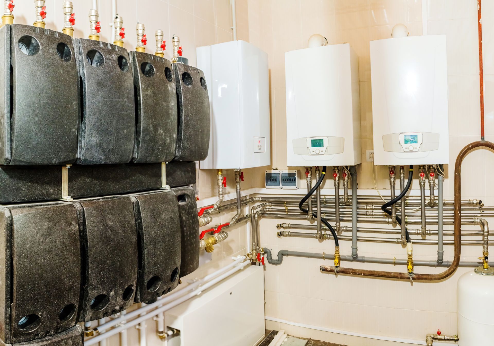 Wall-mounted water heaters and insulated piping in a utility room