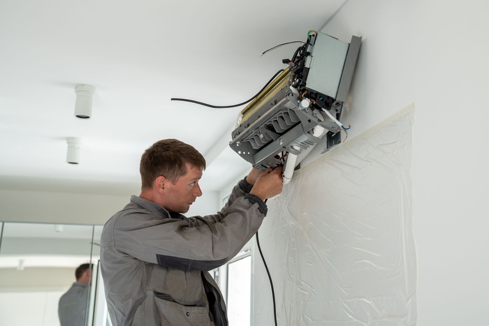 Hand cleaning an outdoor air conditioner unit with a spray bottle