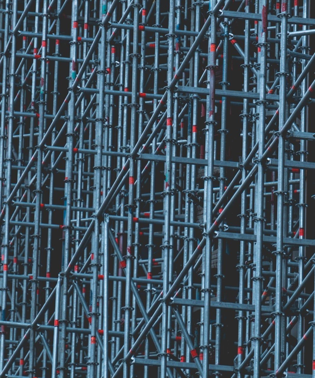 Una fitta impalcatura blu-grigia con connettori rossi forma una struttura di costruzione.