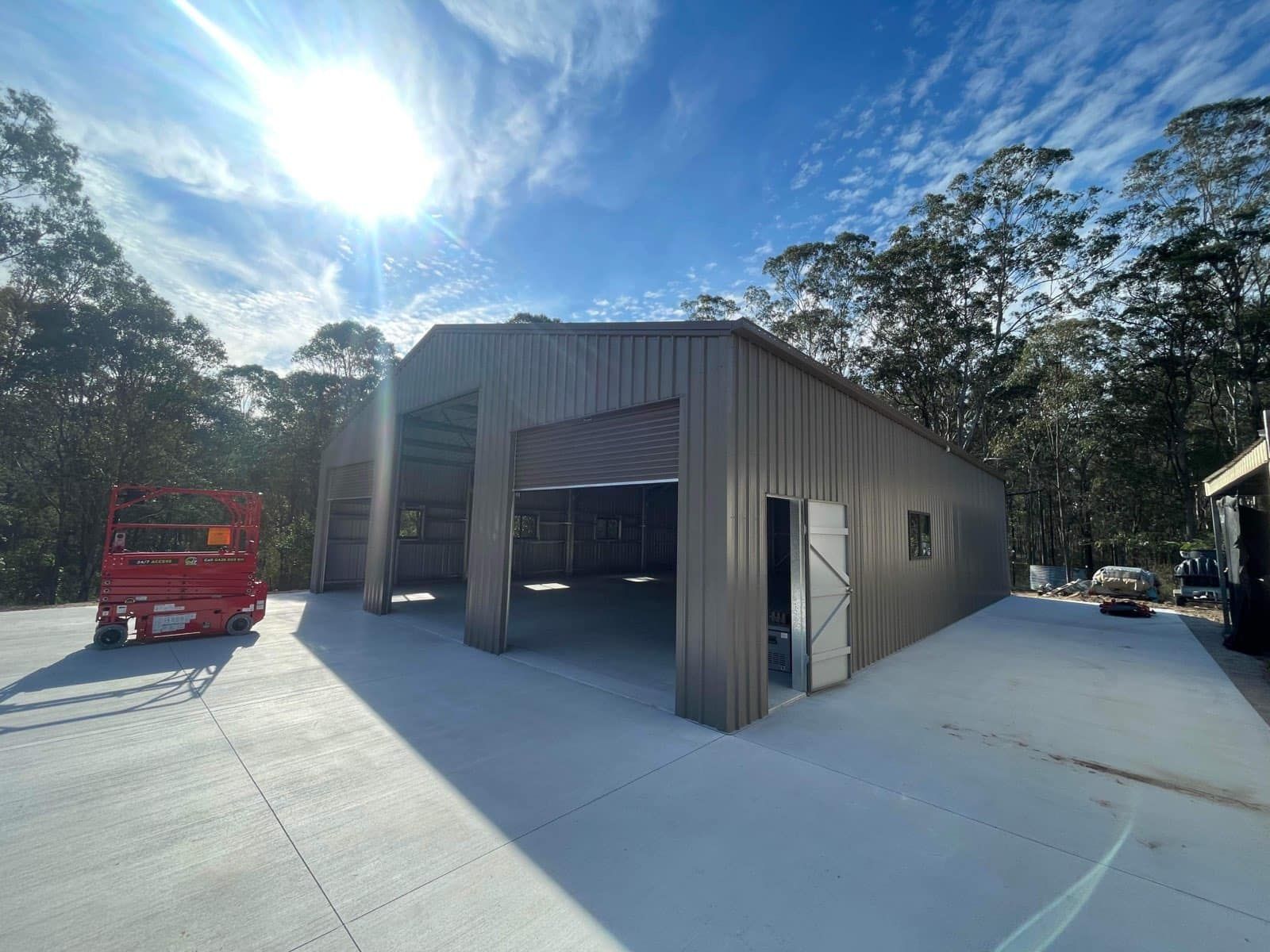 A large metal building with a lot of windows is being built. — Just Sheds In Kunda Park, QLD