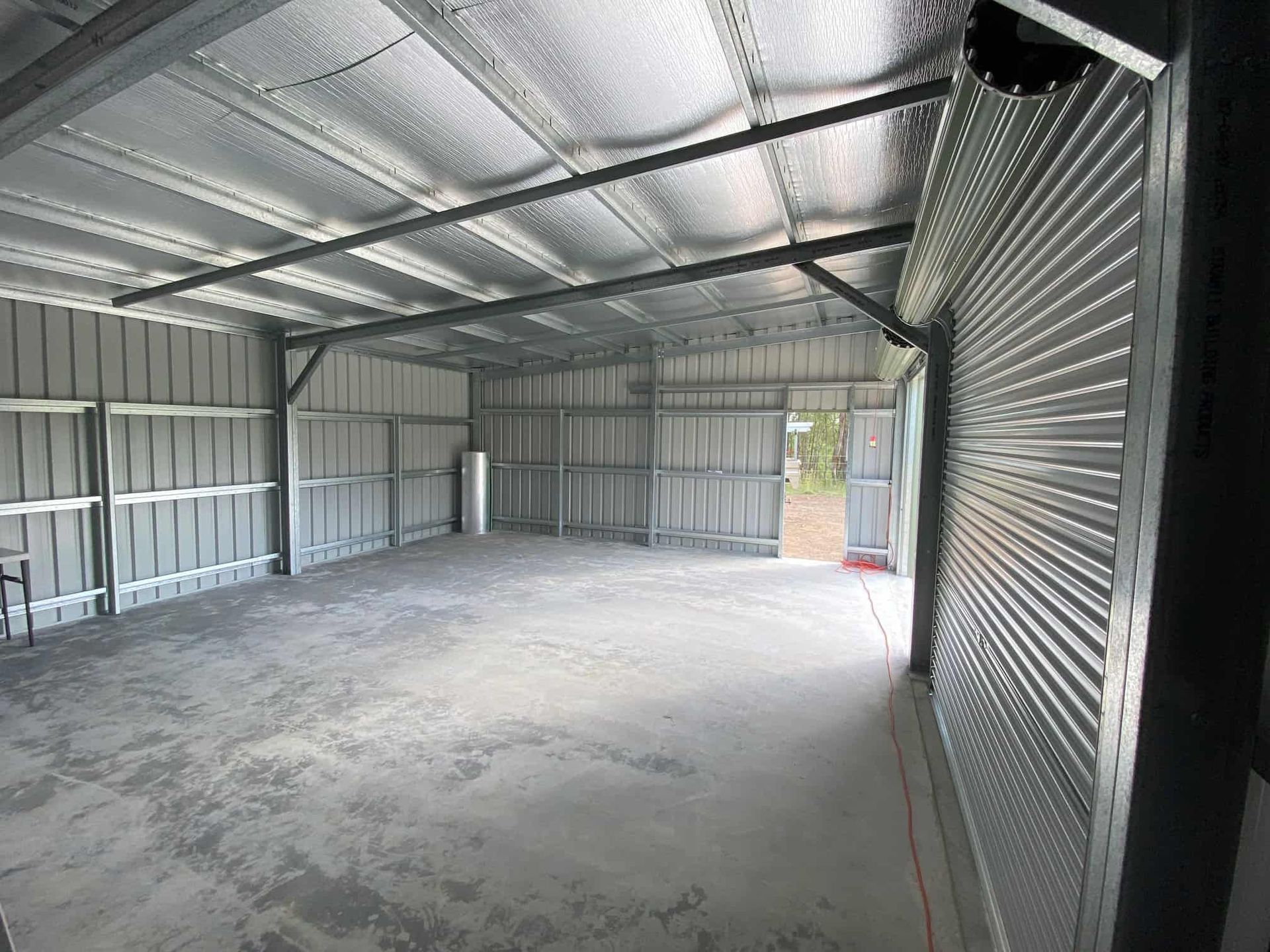 A large empty garage with a concrete floor and a metal roof. — Just Sheds In Kunda Park, QLD