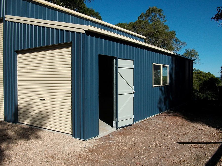 A Blue Building With a White Door and a Window — Just Sheds In Kunda Park, QLD