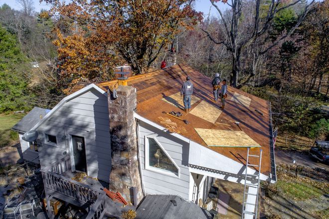 Experienced roof replacement contractors working on a residential roofing project.