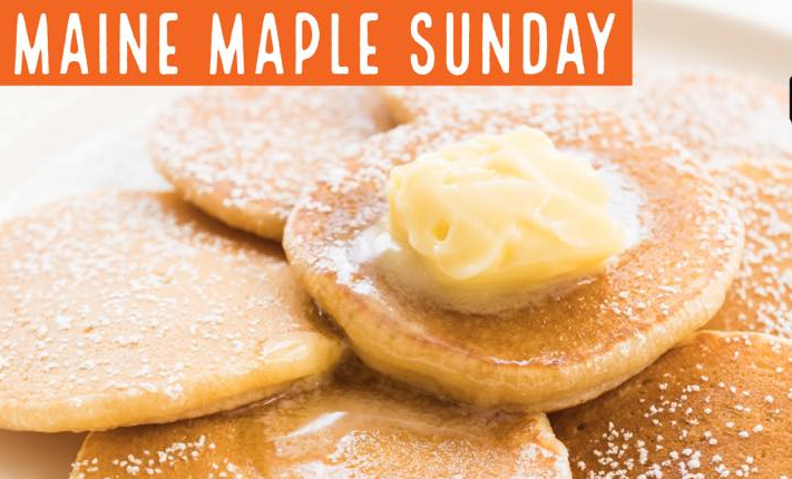 A plate of golden-brown pancakes topped with a pat of butter, lightly dusted with powdered sugar, titled Maine Maple Sunday.