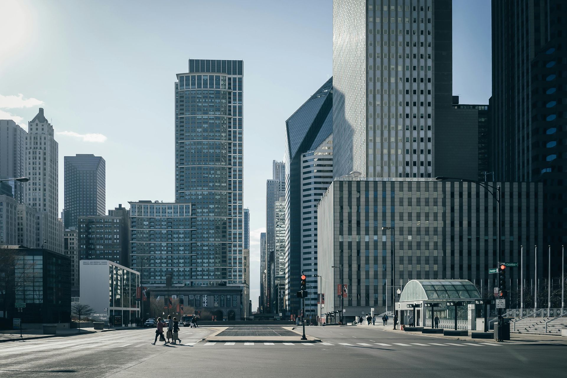 Wide city street with tall modern skyscrapers under a clear sky
