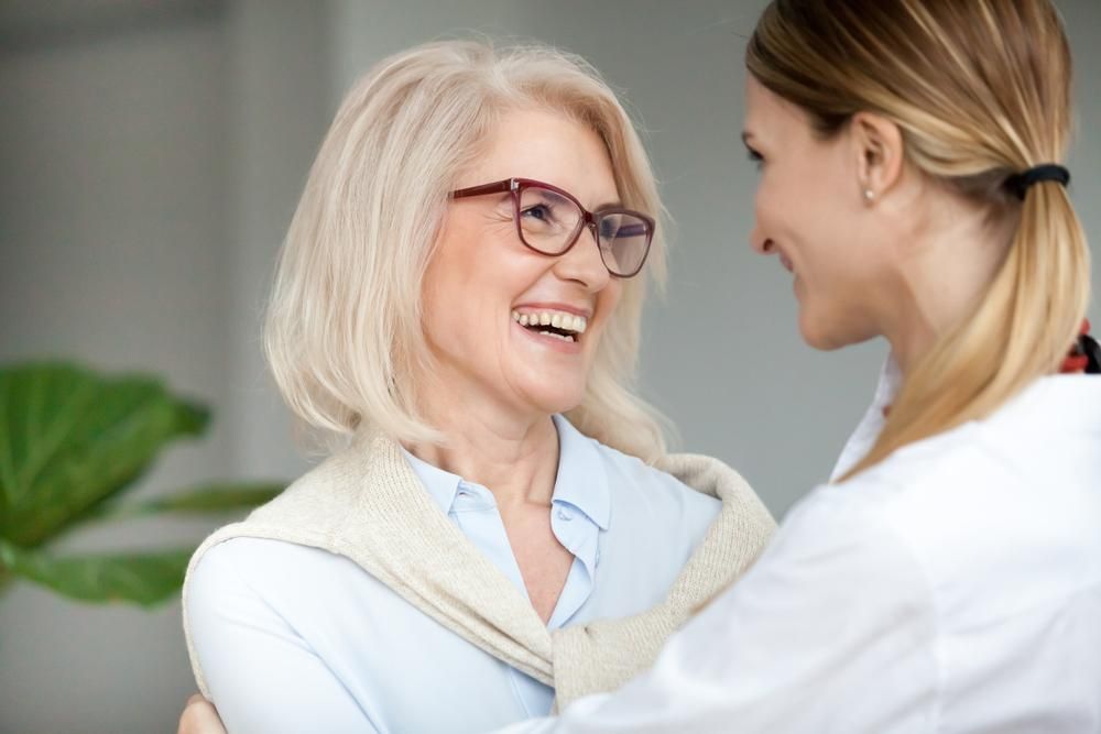 A Nurse Is Hugging An Older Woman Who Is Wearing Glasses — Howells & Co Legal & Conveyancing In Cessnock, NSW